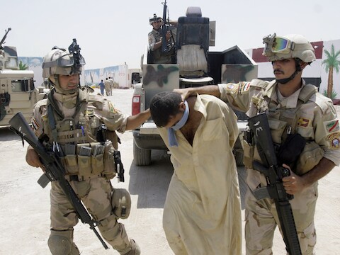 Iraakse soldaden met een man die verdacht wordt lid van al-Qaida te zijn.