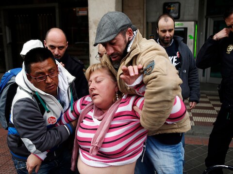 Een Madrileense vrouw die haar huis werd uitgezet wordt geholpen nadat ze een paniekaanval kreeg tijdens een protestactie.