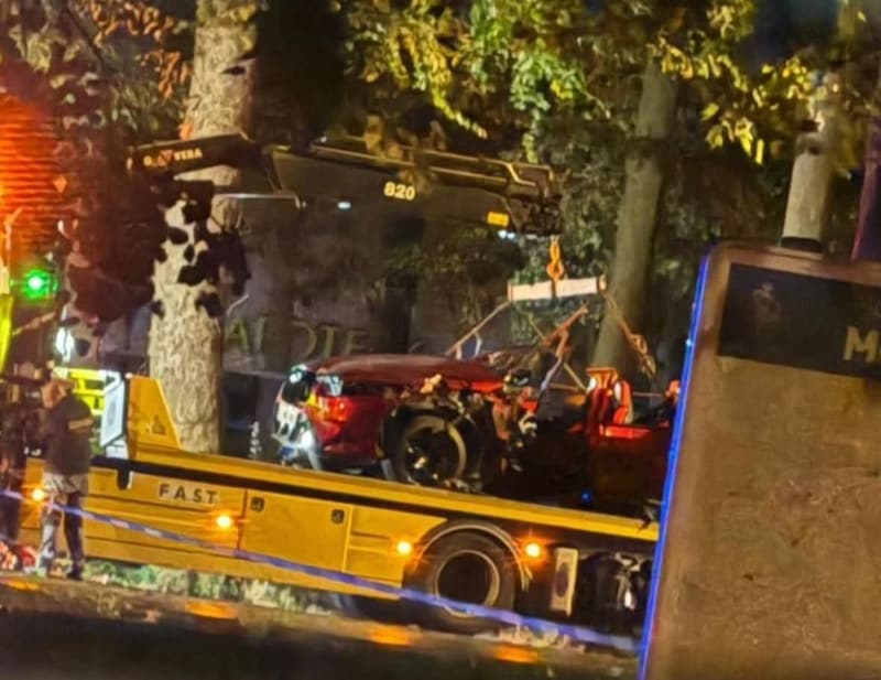 De zwaar beschadigde BMW M5 wordt zondagvoormiddag in Evergem getakeld na het dodelijke ongeval in de Doornzele Dries.