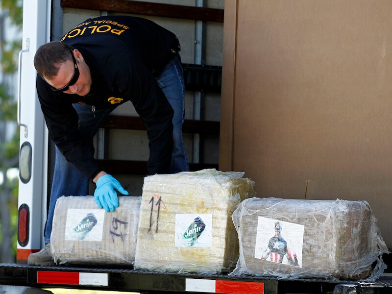 Een Amerikaanse agent met enkele paketten marihuana in Otay Mesa, Californië.