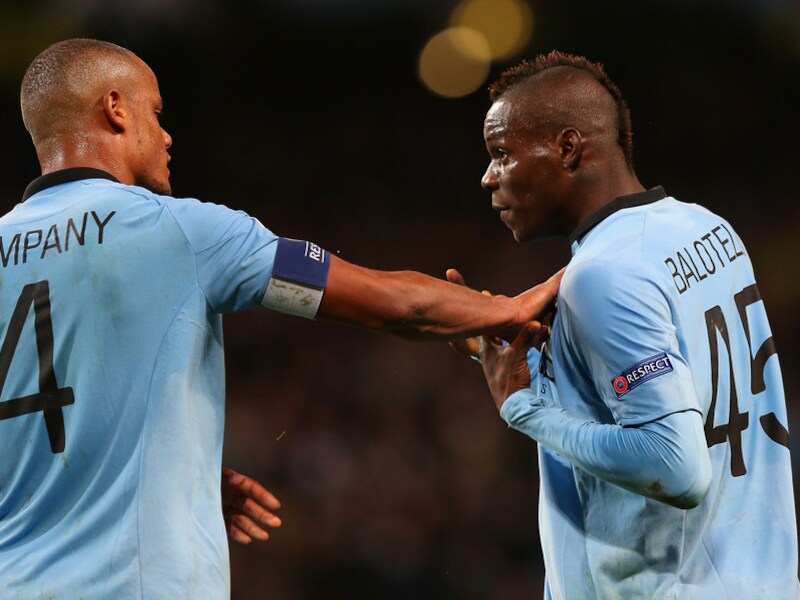 Kompany moet Balotelli afhouden, die in de slotseconden terecht een strafschop claimde.
