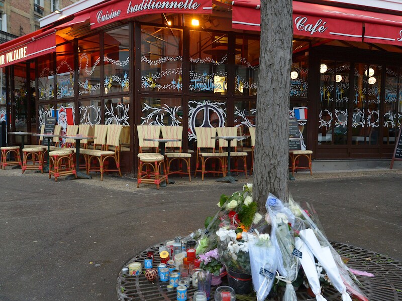 Voor een van de getroffen restaurants in Parijs liggen bloemen.