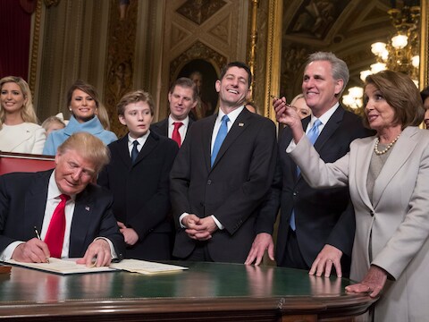 Omringd door familie en politieke zwaargewichten tekent president Trump zijn eerste besluiten.