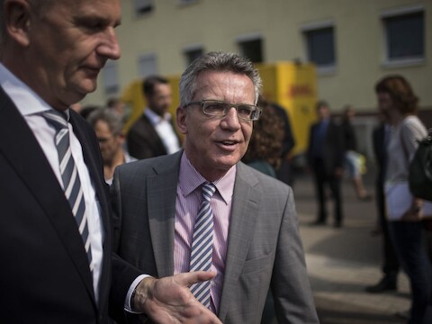 Duits minister van Binnenlandse Zaken Thomas de Maiziere (midden) bij een bezoek aan een asielcentrum nabij de Poolse grens.