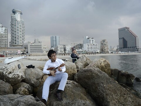 Een toerist op het strand in Tel Aviv, net nadat de wapenstilstand werd afgekondigd.