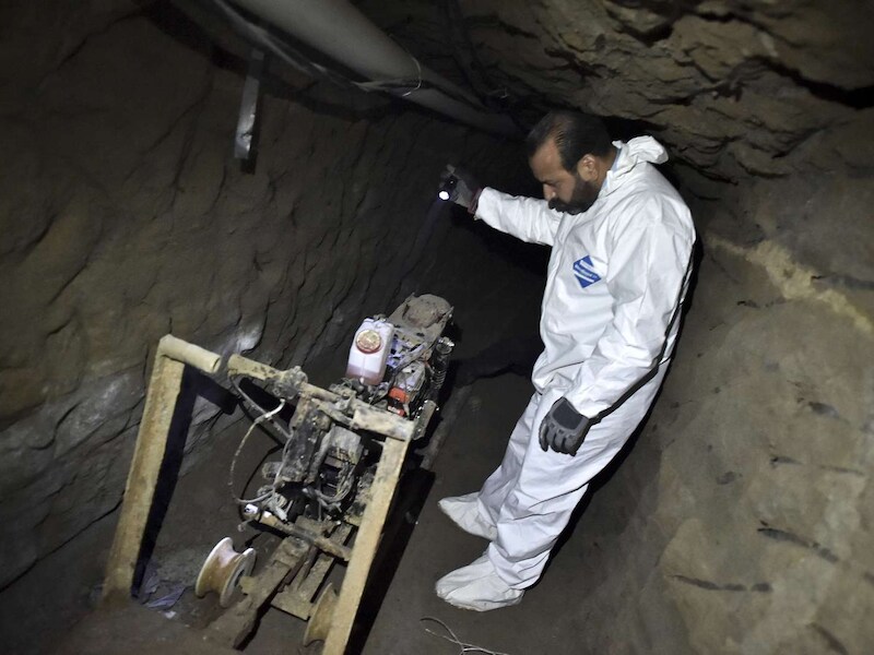 Een onderzoeker inspecteert een motor in een tunnel die 'El Chapo' gebruikt zou hebben om te ontsnappen.