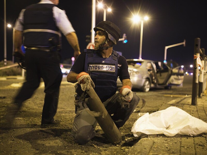 Een Israëlische expert in explosieven van de politie verwijdert de restanten van een raket uit Gaza.