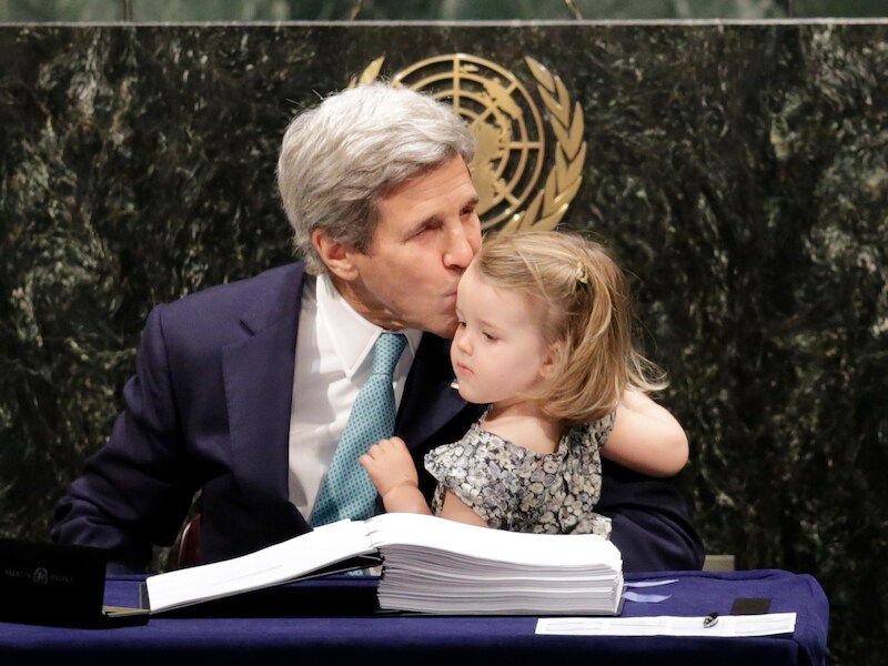 De Amerikaanse minister van Buitenlandse Zaken John Kerry kust zijn kleindochter na het ondertekenen van het akkoord.