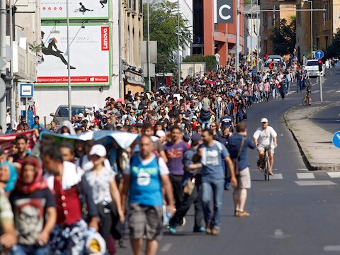 Migranten wandelen in een van de hoofdstraten van Boedapest.