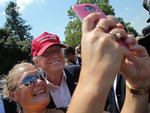 Een vrouw neemt een selfie met presidentskandidaat Donald Trump.