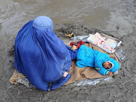 Eem Afghaanse vrouw en haar kind bedelen in Kabul om giften.