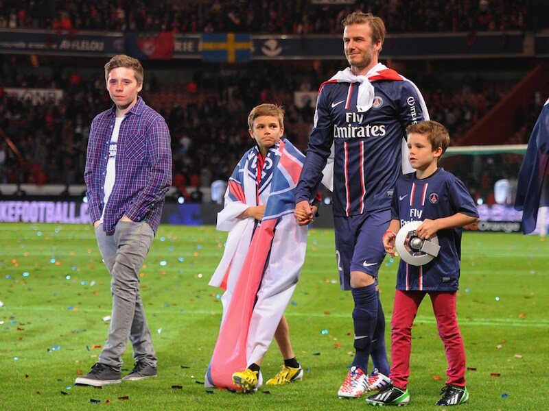 David Bechkam maakt met zijn zonen Brooklyn (links), Romeo en Cruz (rechts) een ereronde bij PSG.