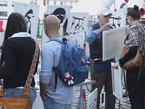 De vrouw rechts koopt een werk van een door Banksy ingehuurde marktkoopman. Zij kan een financiële klapper maken.
