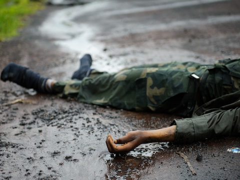 Het lichaam van een dode Congolese soldaat ligt op de weg tussen Goma en Kibati.