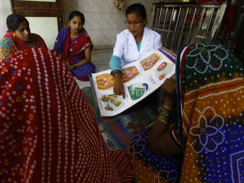 Een medewerkster van het Tata Memorial ziekenhuis in India legt enkele vrouwen het gevaar van baarmoederhalskanker uit.