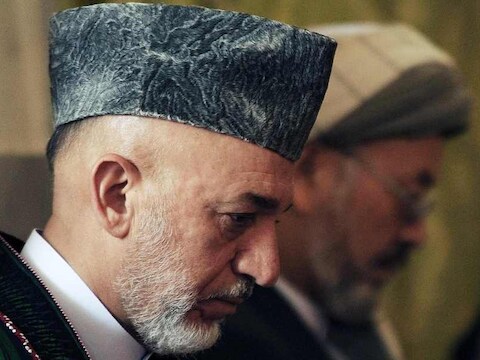 Hamid Karzai op de begrafenis van zijn halfbroer.