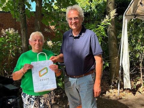 Anni De Koning ontvangt een bon ter waarde van 250 euro en een goodiebag van Essen uit handen van schepen van Leefmilieu Helmut Jaspers.
