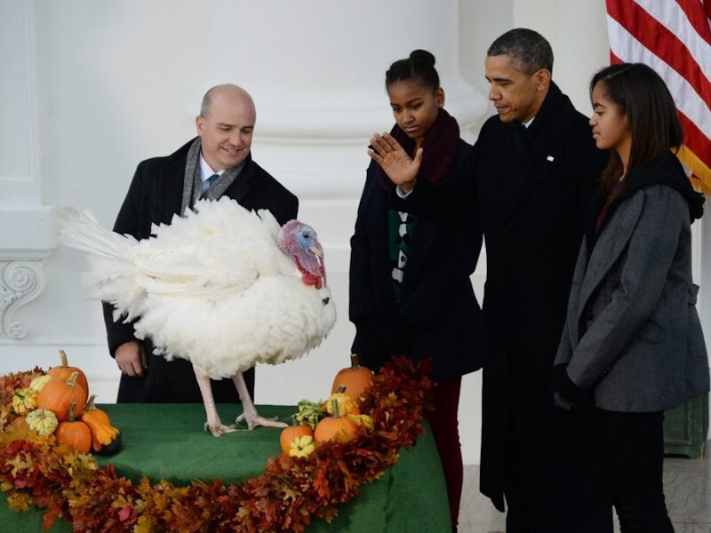 Obama, in gezelschap van zijn dochters Malia (R) en Sasha en de voorzitter van de Amerikaanse Kalkoen Federatie John Burke (L), verleent Popcorn gratie.