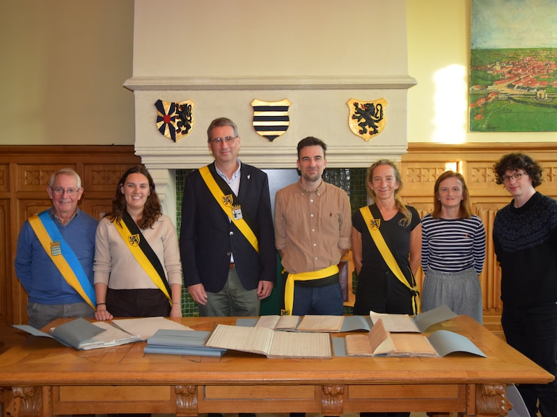 Een beeld van de overdracht. We zien Martin Obin (voorzitter van de gemeenteraad stad Diksmuide), Herlinde Rollez (schepen Diksmuide), Jan Deheegher (schepen Lo-Reninge), Koen Coupillie (burgemeester Diksmuide), Katleen Winne (schepen Diksmuide), Stefanie Eeckhout (deskundige archief- en informatiebeheer DVV Westhoek) en Gert-Jan Van de Voorde (deskundige erfgoed stad Diksmuide).