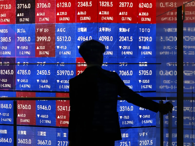 Een man in Japan ziet rode cijfers op de beurs.