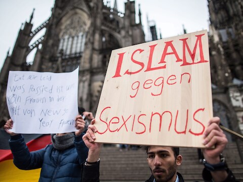 Een Syriër houdt een bord omhoog waarin hij afstand neemt van de aanrandingen in Keulen.