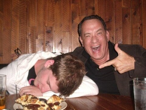 Tom Hanks en een gelukkige fan die doet alsof hij ladderzat naast zijn 'beste kameraad' ligt.