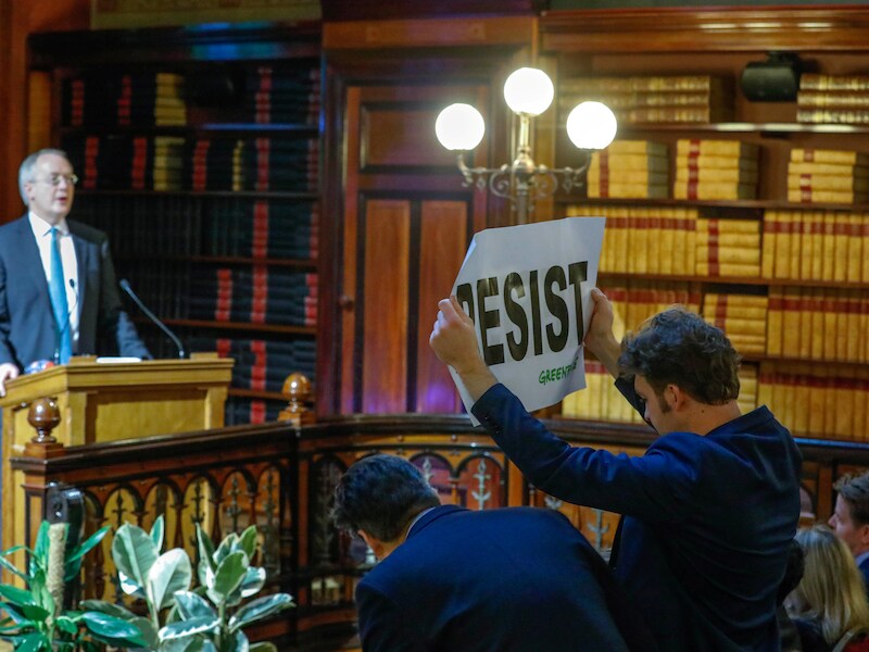 Een Greenpeace-activist verstoort de speech van Myron Ebell met een spandoek en wat boegeroep.