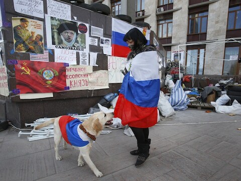 Een activist draagt een Russische vlag in de buurt van een bezet overheidsgebouw in Donetsk, Oekraïne.