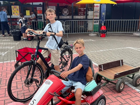 Jasper en Arthur (r) staan aan de carrefour van Rumst en bengen tegen een kleine vergoeding boodschappen van de festivalgangers tot aan de camping.
