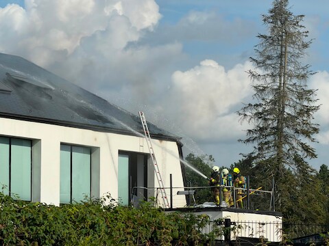 Brandweermannen bestrijden de zolderbrand in de woning in Zoersel.