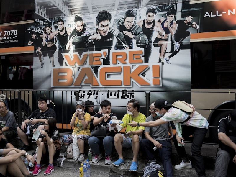 Demonstranten zitten voor een bus in Hongkong