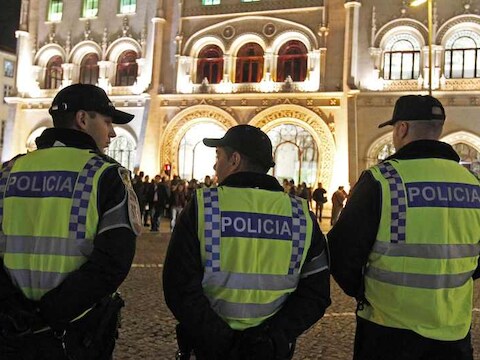 Agenten houden betogers in de gaten in Lissabon.