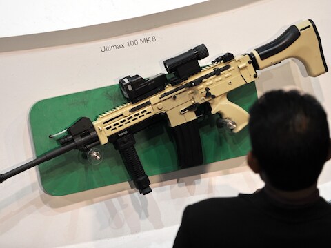 Een bezoeker van een beurs bekijkt een Ultimax 100 MK8, een wapen van Singaporese makelij.