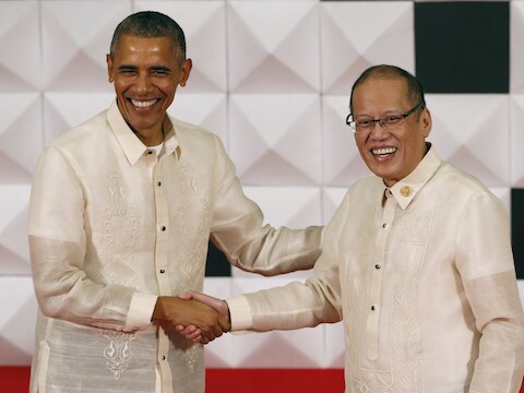 Obama, in een traditioneel Filipijns baronghemd, schudt de hand van de Filipijnse president Benigno Aquino op het galadiner van de Asia-Pacific Economic Cooperation.