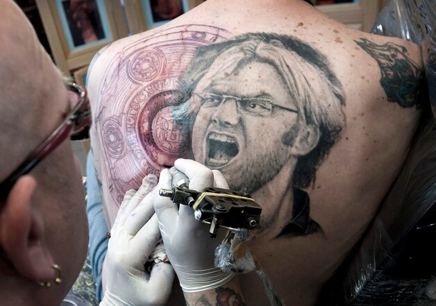Een fanatieke supporter van Dortmund (niet de man in kwestie) laat een tatoeage van Borussia-trainer Klopp op zijn rug zetten.