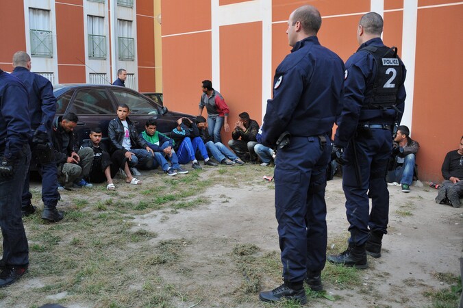 Franse politiemannen bij Tunesische vluchtelingen die tijdens een raid werden opgepakt.