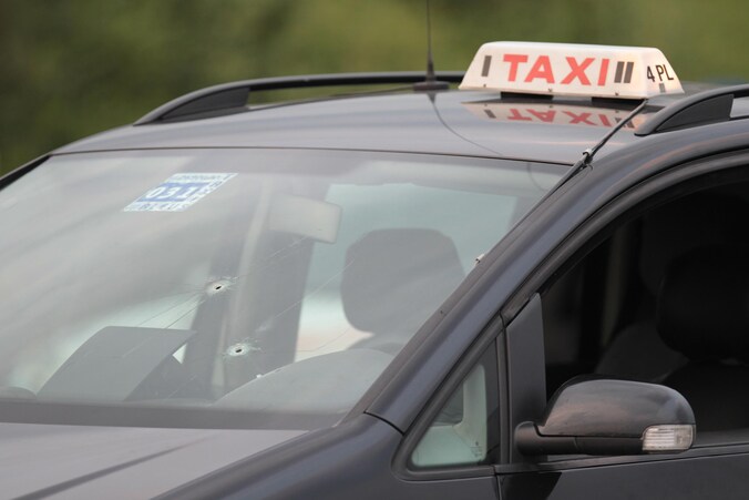 In de voorruit van de taxi zitten twee kogelgaten.