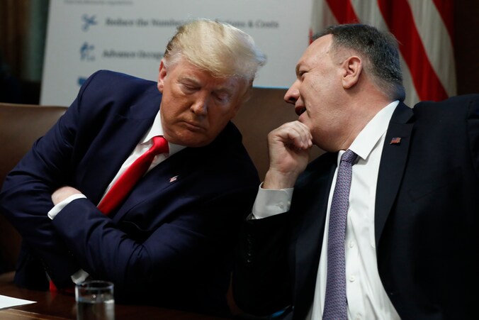 De Amerikaanse minister van Buitenlandse Zaken fluistert de Amerikaanse president Trump iets toe tijdens een kabinetsvergadering.