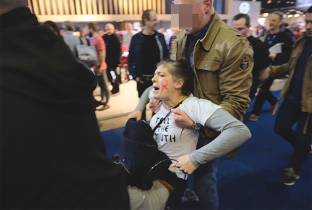 Een actievoerder van Extinction Rebellion wordt opgepakt op het Autosalon