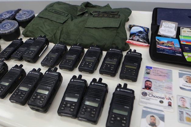 Een foto die door de Venezolaans autoriteiten werd vrijgegeven met daarop identiteitskaarten, communicatie-apparatuur, pinpassen en een legeruniform. (04/05/2020)