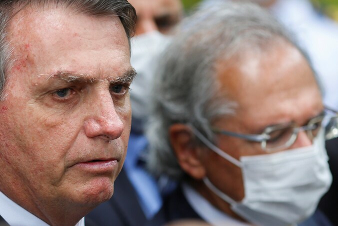 De Braziliaanse economieminister Paulo Guedes (met mondkapje) naast president Jair Bolsonaro.