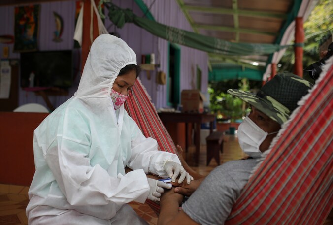 Een verpleegster meet het zuurstofgehalte in het bloed van Raimundo Cruz da Silva (42) in het dorpje Tres Unidos, in de staat Amazonas in Brazilië (21/05/2020).