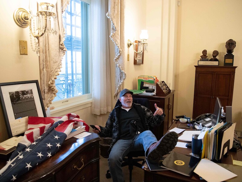 Relschopper Richard Barnett smeet op 6 januari tijdens de bestorming van het Capitool zijn voet op het bureau van House Speaker Nancy Pelosi.