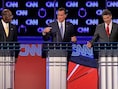 Herman Cain (L) beschuldigt Rick Perry (R), die de zwarte piet dan weer doorschuift naar Mitt Romney (C).