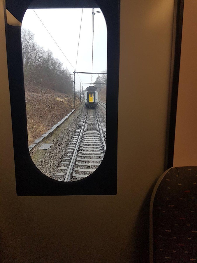 Twee treinwagons zijn losgekomen van de rest van de trein en staan stil op de sporen.