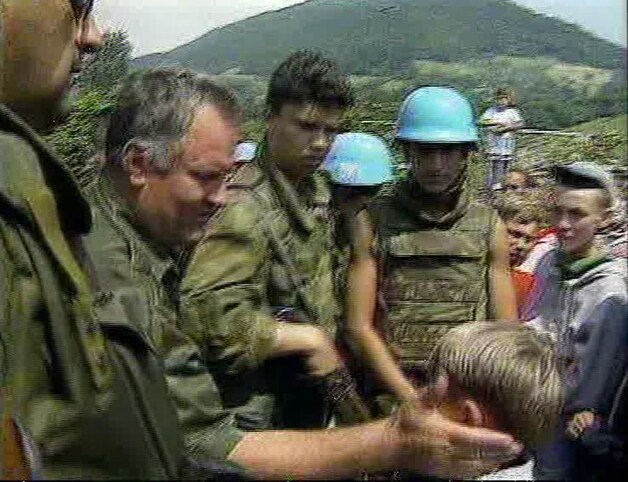 Lichtbewapende Nederlandse Blauwhelmen stonden machteloos toen de Bosnisch-Servische troepen van Ratko Mladic de moslim-enclave Srebrenica in volle Bosnische burgeroorlog op 11 juli 1995 onder de voet liepen. Mladic liet eerst nog snoep uitdelen aan kinderen, toen de cameraploegen vetrokken waren werden vrouwen en kinderen gescheiden van mannen. Bij moordpartijen door de Bosnische-Servische troepen zijn in de dagen erna naar schatting 8.000 moslimmannen -en jongens om het leven gekomen.