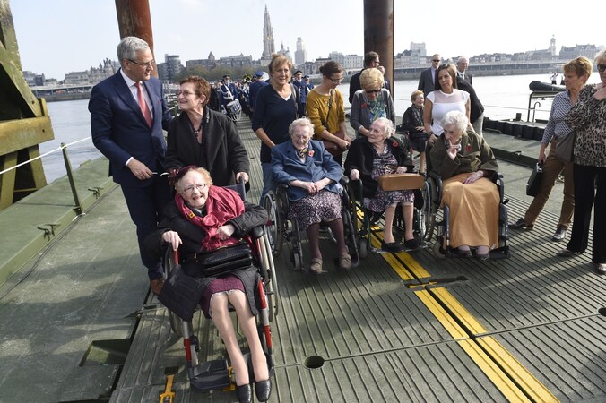 Josée wordt in haar rolstoel over de Vredesbrug geduwd, samen met nog enkele andere 100-jarigen. "Dat ik dit nog mag meemaken, is uniek."
