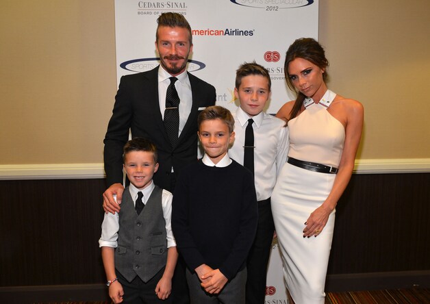 Victoria en David met hun drie zonen Cruz (L), Romeo (C) en Brooklyn (R).