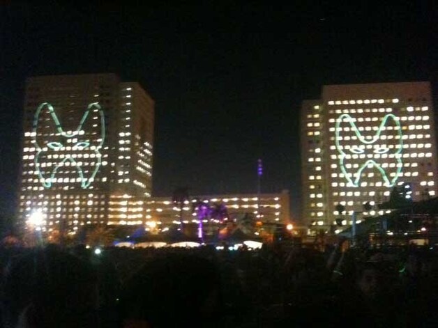 Aan de overkant van het podium lichten vlak voor de show twee gigantische maskers op, of hoe het Masquerade Motel-aspect volledig uit te spelen.