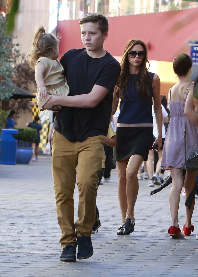 Brooklyn Beckham met zusje Harper op de arm